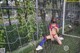 A woman wearing a face mask sitting in front of a soccer goal.