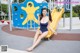 A woman in a blue bathing suit sitting on a yellow slide.