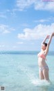 A woman in a bikini standing in the ocean.