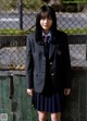 A young woman in a school uniform posing for a picture.