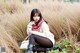 A woman sitting in a field of tall grass.