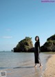 A woman standing on a beach next to the ocean.