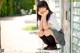 A woman sitting on a bench with her hand on her chin.