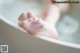 A baby's feet in a bathtub with bubbles.