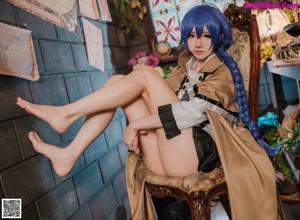 A woman with blue hair sitting on a chair.